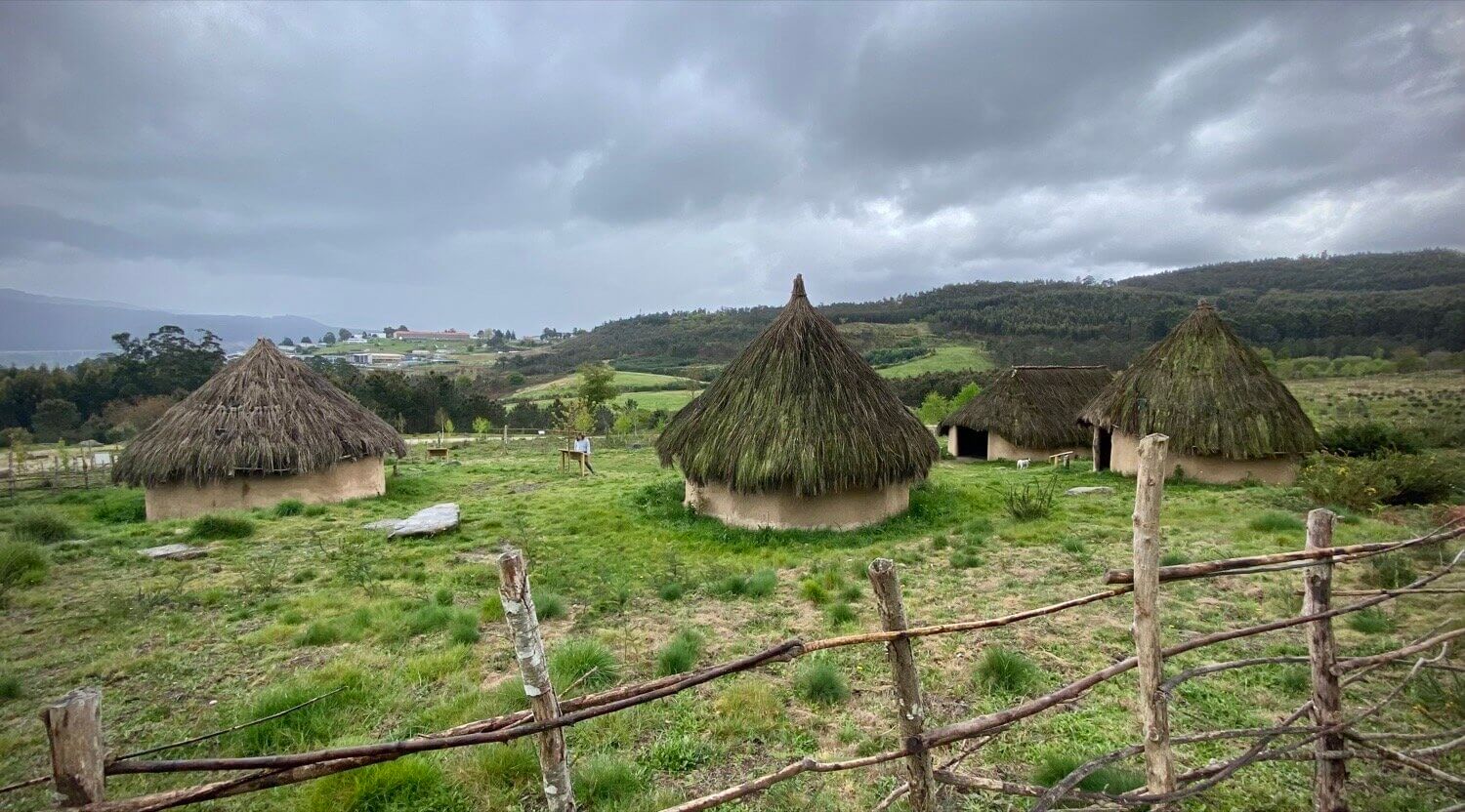 Cabaña Comunal. Es la construcción de mayor tamaño: 12m de largo por unos 5m de ancho con cabeceras redondeadas. Por sus dimensiones la estructura ha sido reforzada con un sistema de columnas y vigas sobre las que descansan los durmientes del techo, restándole peso al conjunto. El techo es a dos aguas cubierto con manojos de "xesta". La función de la cabaña comunal era de servir de espacio para el grupo, para la tribu, un espacio en que el que celebrar asambleas, reuniones, banquetes y rituales...